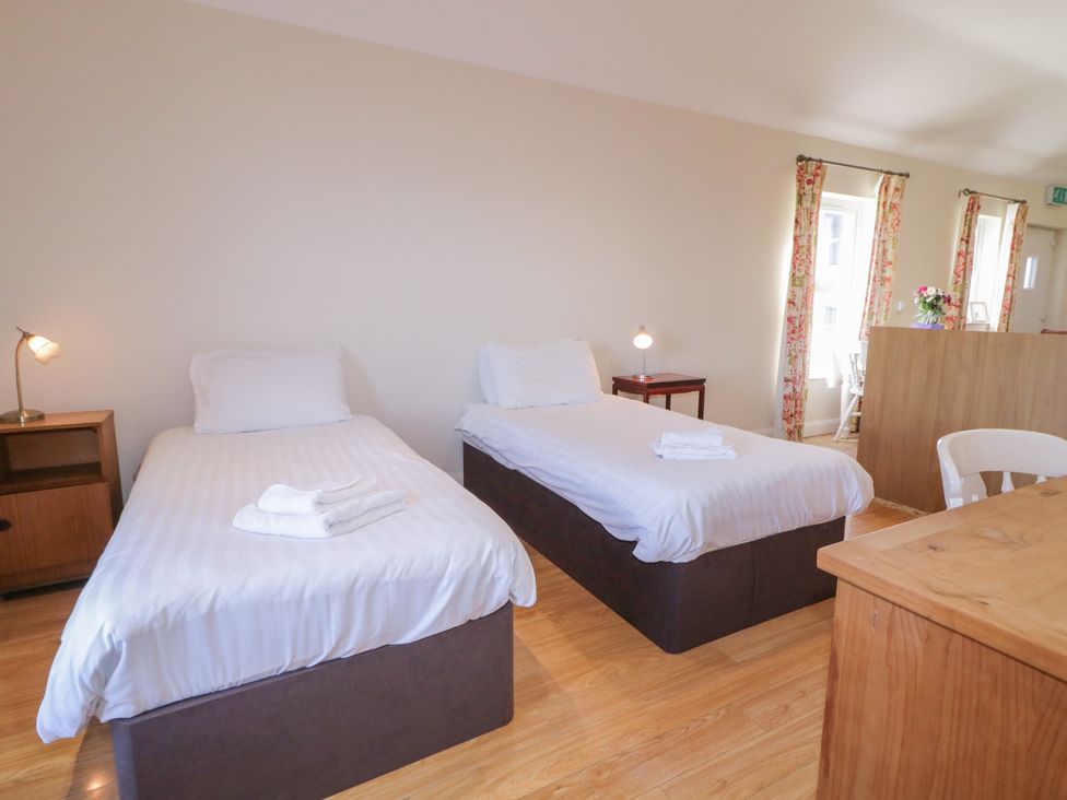 A bedroom with two beds and a desk at Derg Cottage