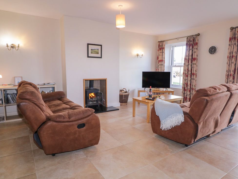 A living room with a sofa and television at Finn Cottage