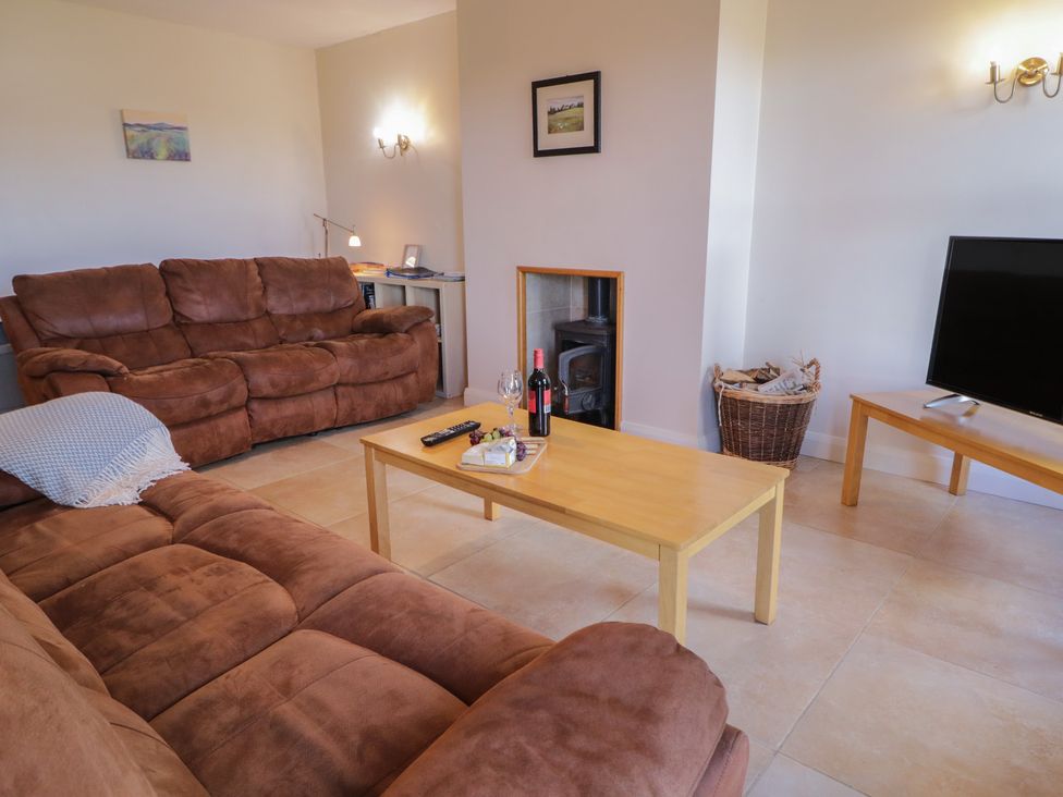 A living room with a sofa and television at Finn Cottage