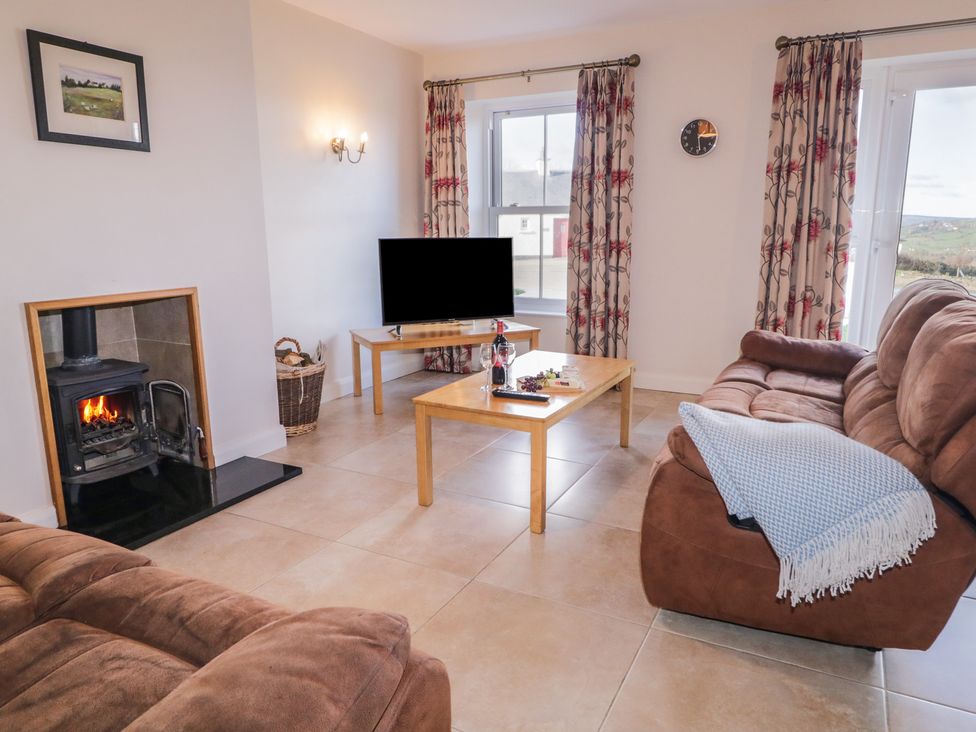 A living room with a television and fireplace at Finn Cottage