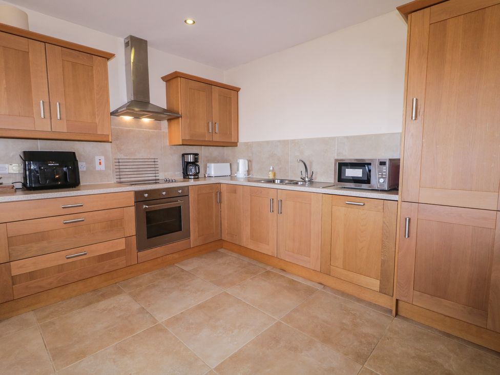 A kitchen with cabinets, appliances, and countertop at Finn Cottage in 
