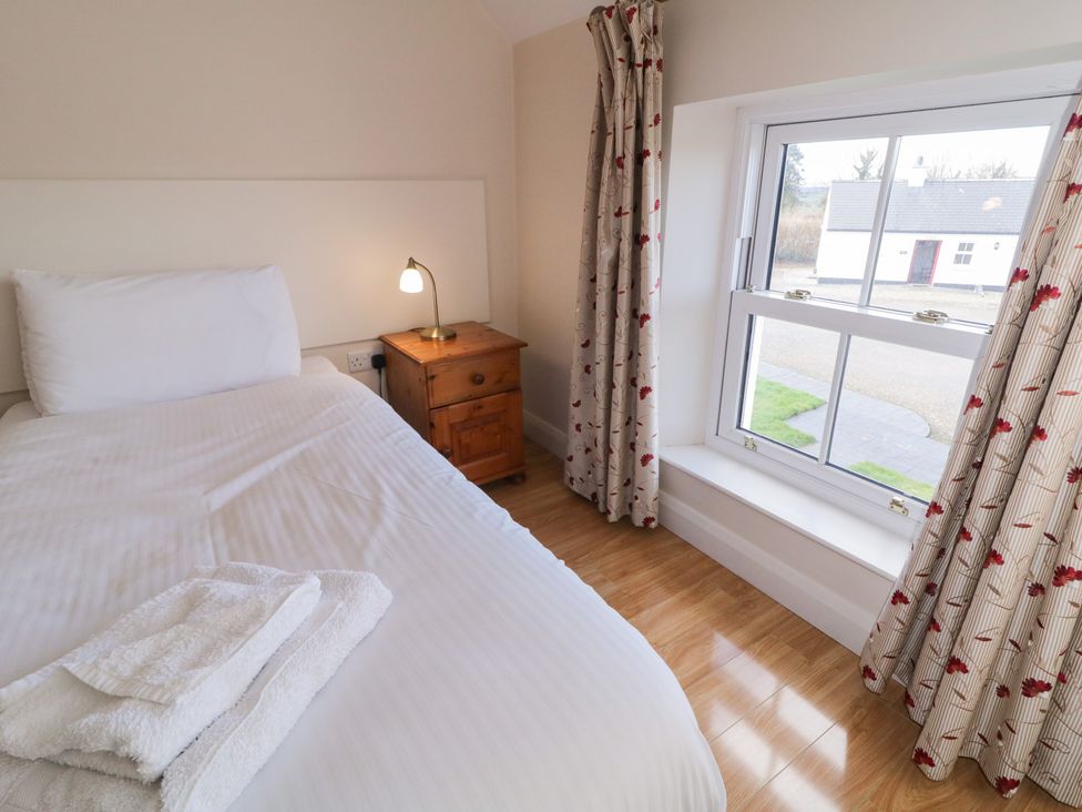 A bedroom with a bed and window at Finn Cottage