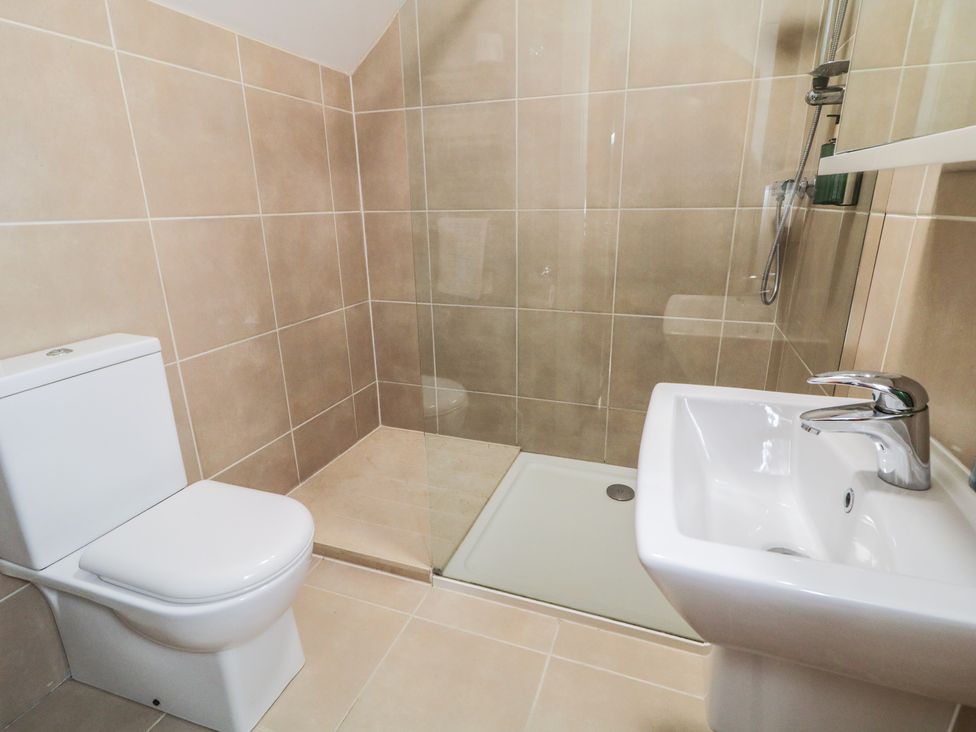 A bathroom with a shower, sink, and toilet at Finn Cottage
