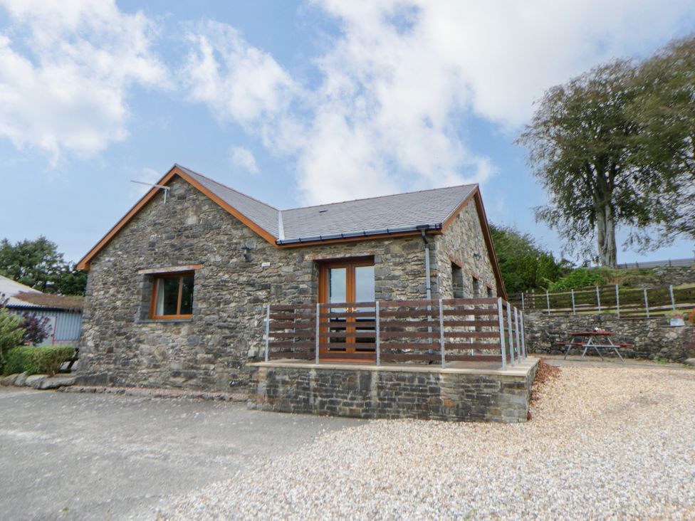 A stone house with a front door and gravel driveway at Y Bwthyn in Swyddffynnon near Pontrhydfendigaid
