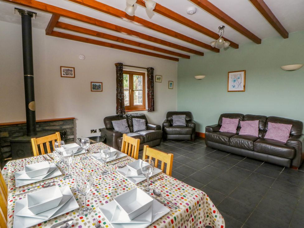 A dining room with a table set for dinner and a sofa at Y Bwthyn in Swyddffynnon near Pontrhydfendigaid