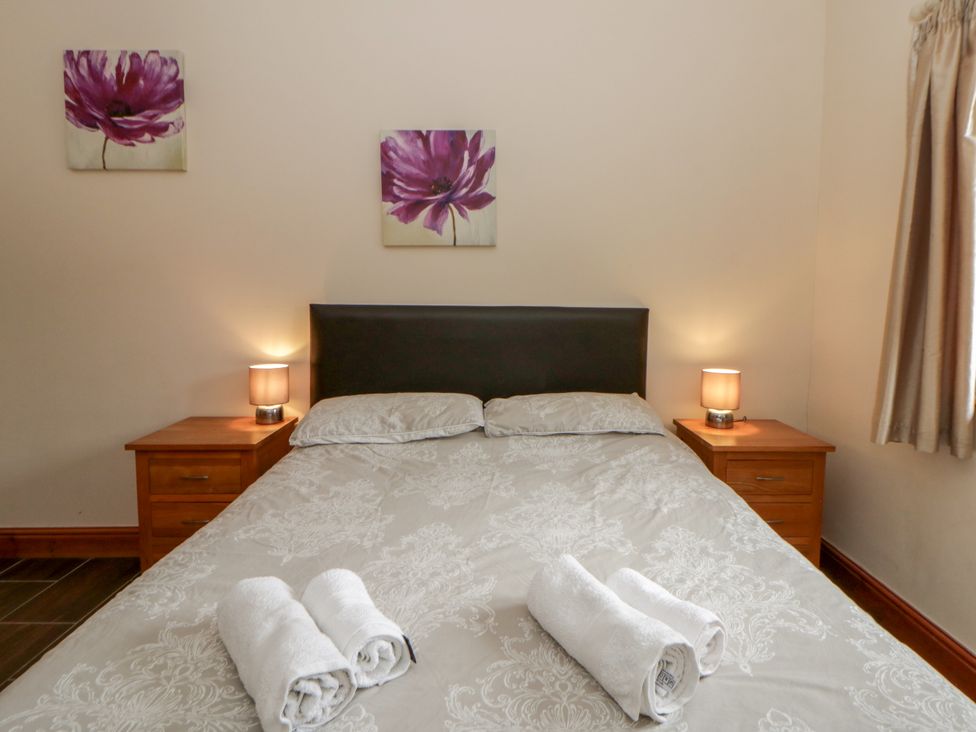 A bedroom with a bed and nightstands at Y Bwthyn in Swyddffynnon near Pontrhydfendigaid