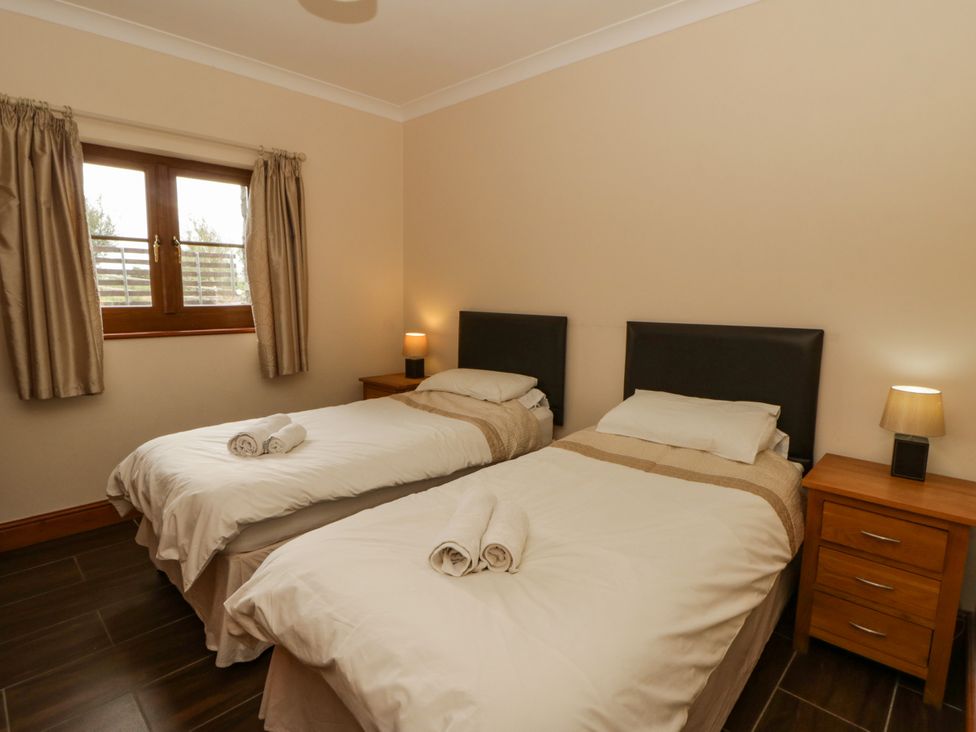 A bedroom with two single beds and a bedside table at Y Bwthyn in Swyddffynnon near Pontrhydfendigaid