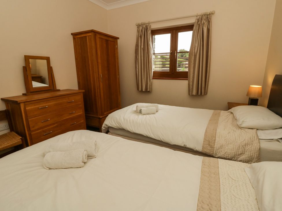 A bedroom with two beds and wooden furniture at Y Bwthyn in Swyddffynnon near Pontrhydfendigaid