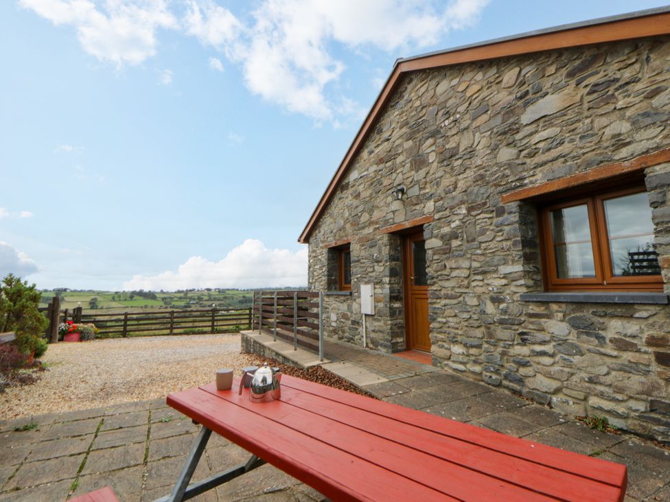 An outdoor seating area with a stone building at Y Bwthyn near Pontrhydfendigaid