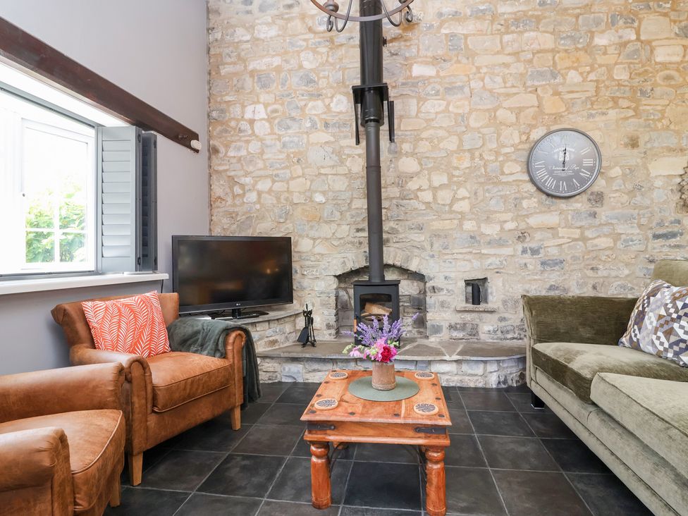 A living room with a wood stove and furniture at Pear Tree Cottage Mark near Burnham-on-Sea