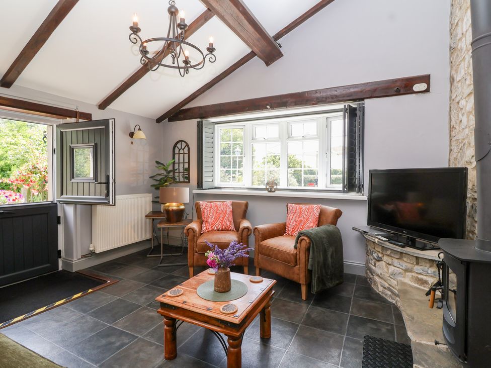 A living room with chairs and a television at Pear Tree Cottage Mark near Burnham-on-Sea