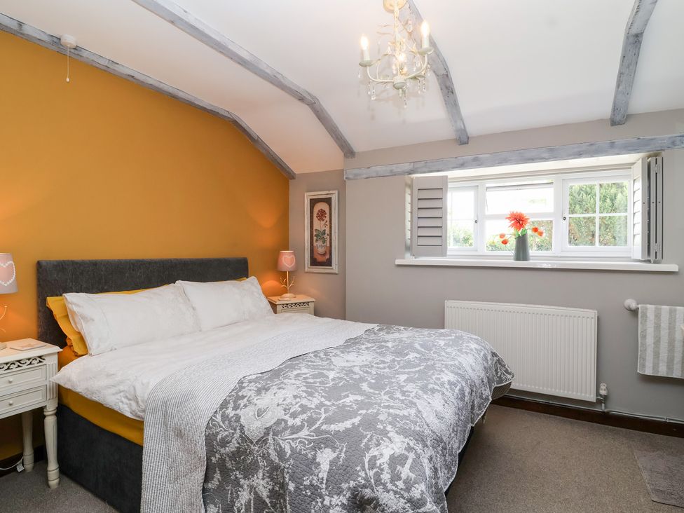 A bedroom with a bed and window at Pear Tree Cottage Mark near Burnham-on-Sea