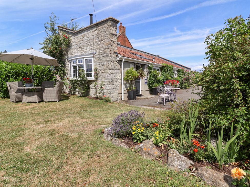 An outdoor area with seating and flowers at Pear Tree Cottage Mark near Burnham-on-Sea