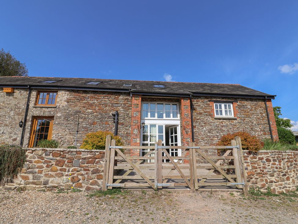 A stone building with a wooden gate at West Bowden Farm in Knowstone near South Molton