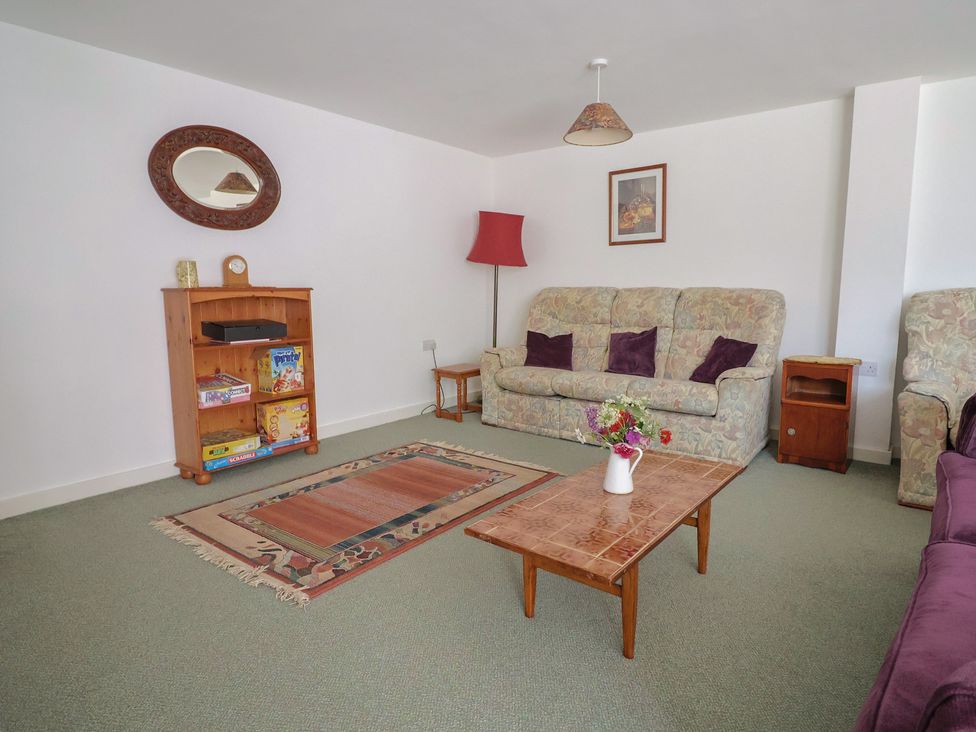 A living room with a sofa and bookshelf at West Bowden Farm in Knowstone near South Molton