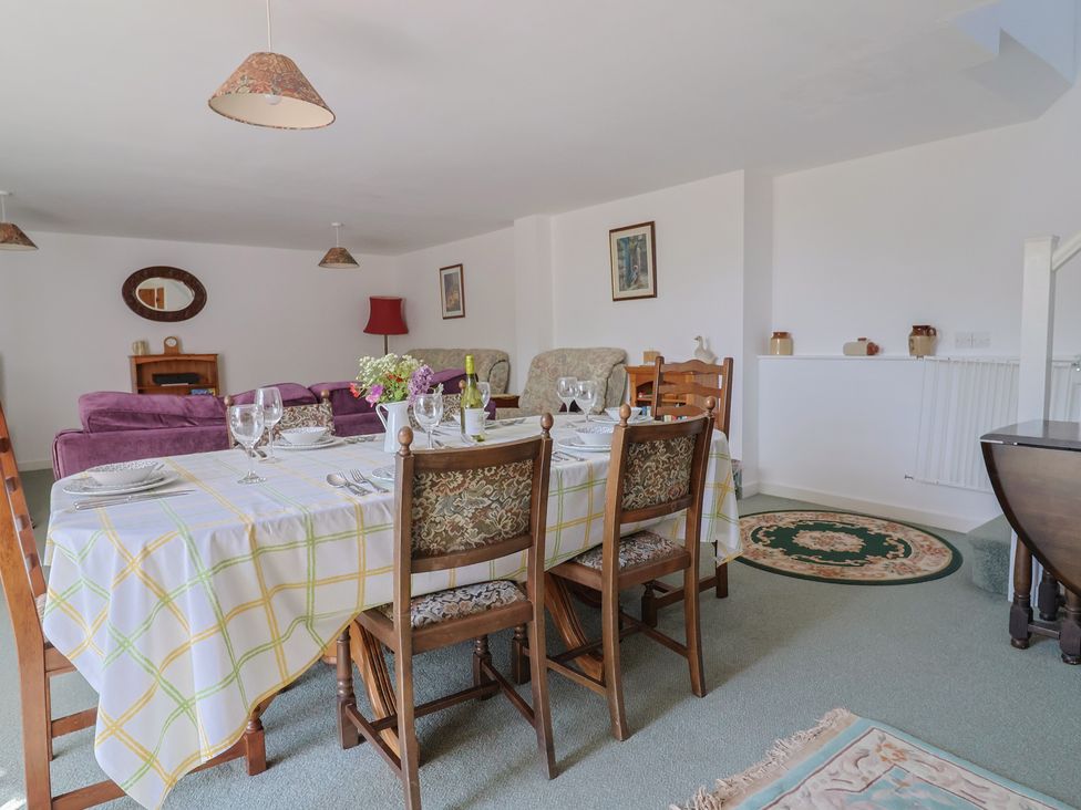 A dining room with a table set for meals at West Bowden Farm in Knowstone near South Molton