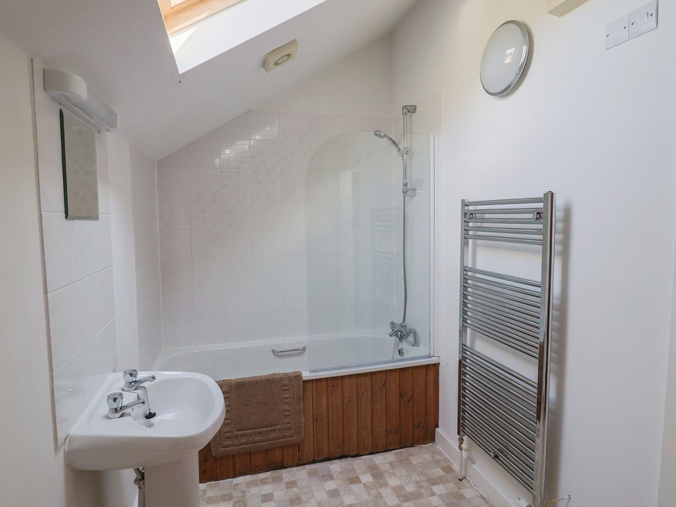 A bathroom with a bathtub, shower, sink and towel rack at West Bowden Farm, Knowstone near South Molton