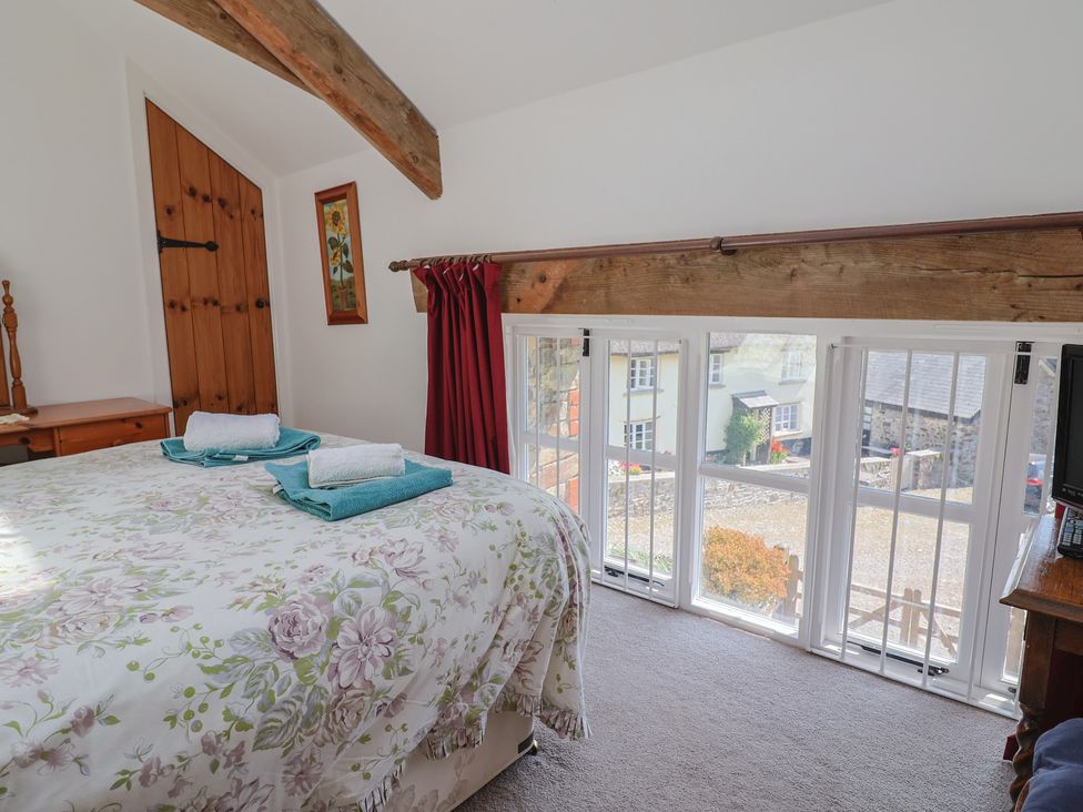 A bedroom with a bed and a window at West Bowden Farm in Knowstone near South Molton