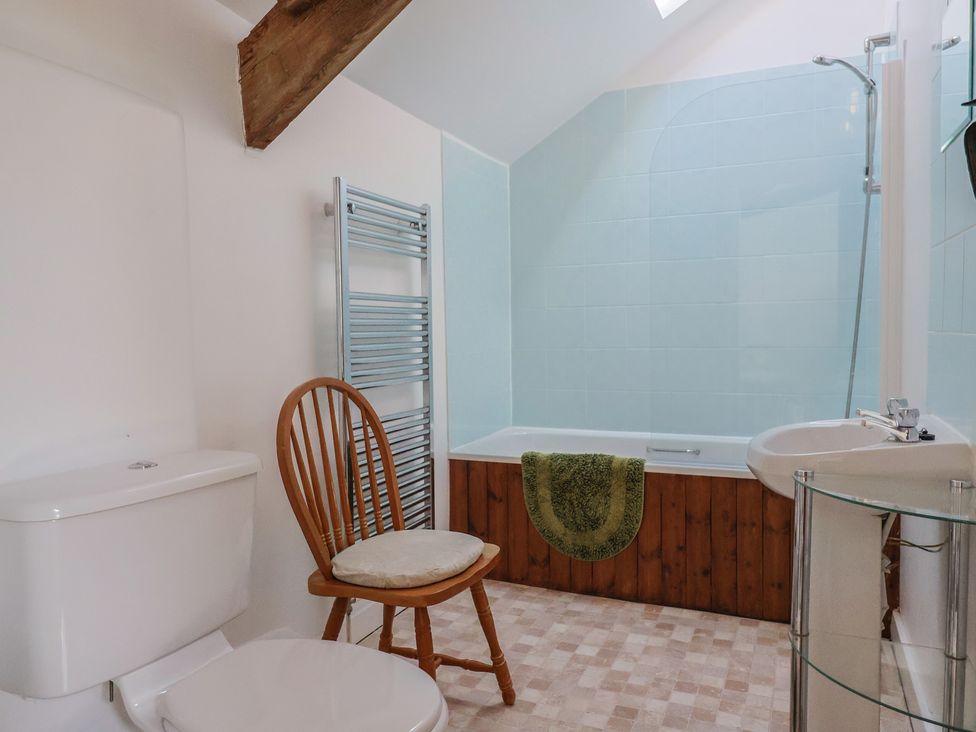 A bathroom with a bathtub, shower, toilet and sink at West Bowden Farm, Knowstone near South Molton