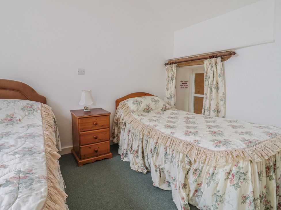 A bedroom with two beds and a bedside table at West Bowden Farm Knowstone near South Molton