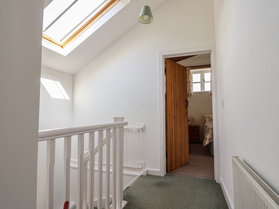 A hallway with staircase and door at West Bowden Farm Knowstone near South Molton