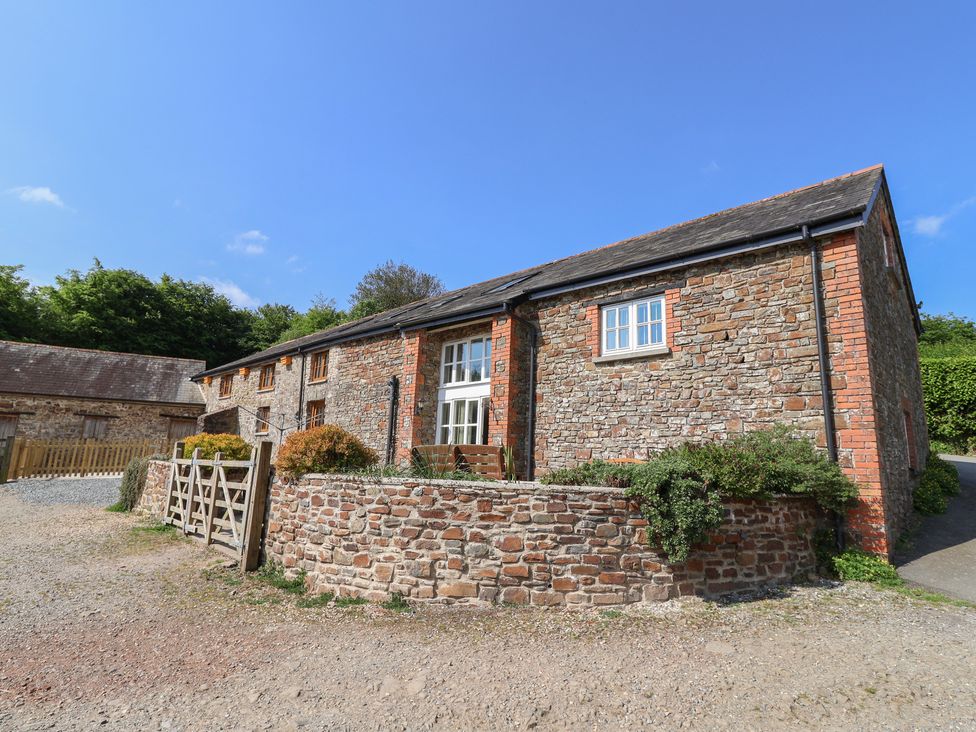 A stone building with windows and a gate at West Bowden Farm Knowstone near South Molton