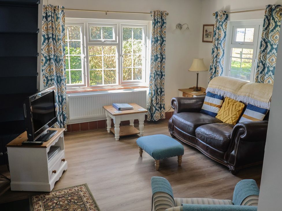 A living room with a sofa and television at The Old Smithy Dottery near Bridport