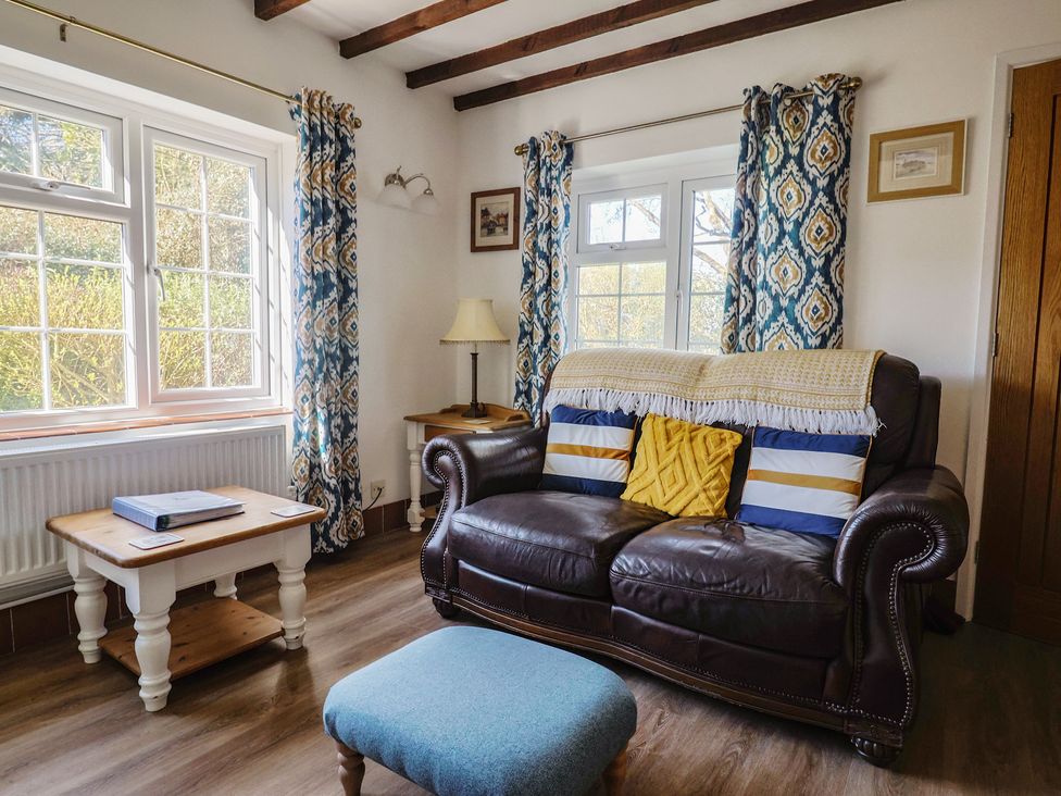 A living room with a sofa and coffee table at The Old Smithy in Dottery near Bridport
