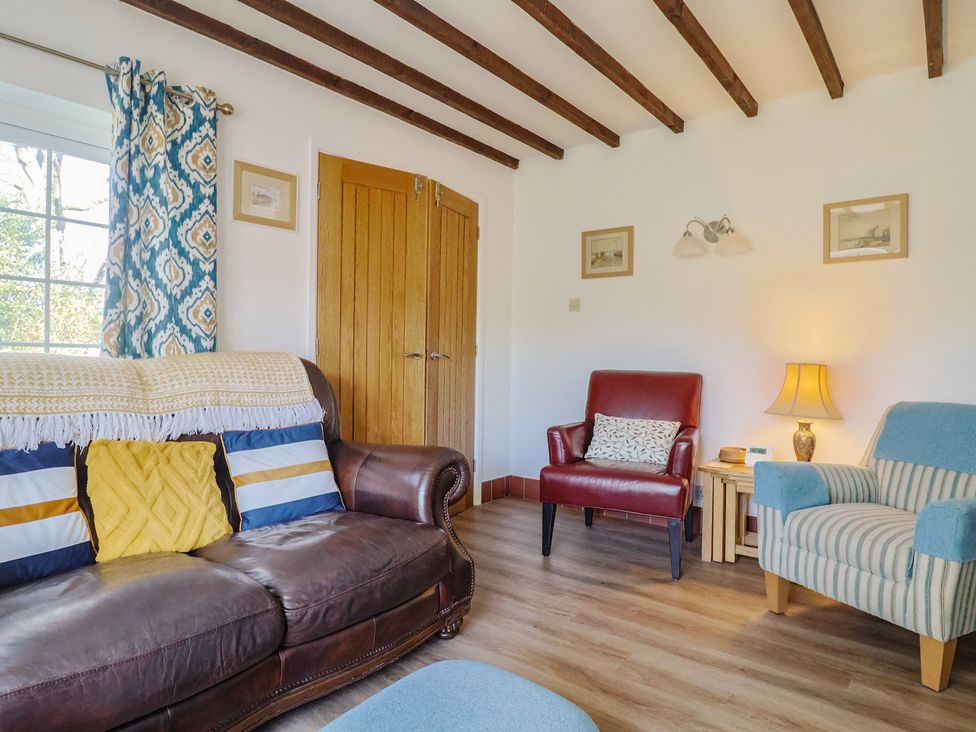 A living room with a sofa and armchair at The Old Smithy Dottery near Bridport