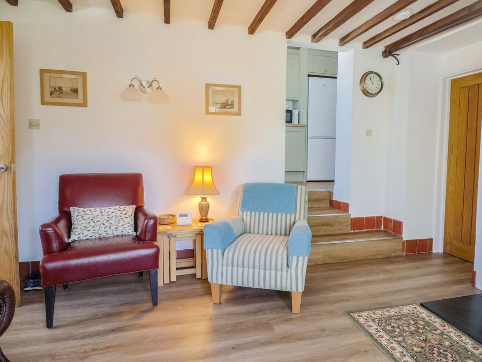 A living room with two armchairs and a lamp at The Old Smithy in Dottery near Bridport