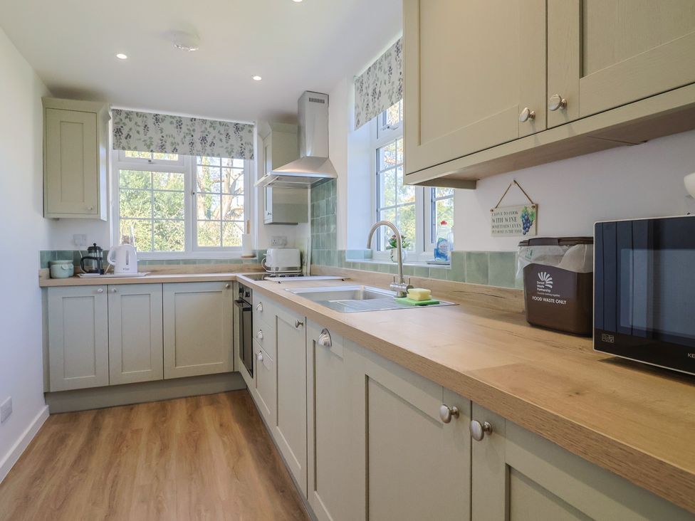 A kitchen with a counter, sink, and appliances at The Old Smithy Dottery near Bridport
