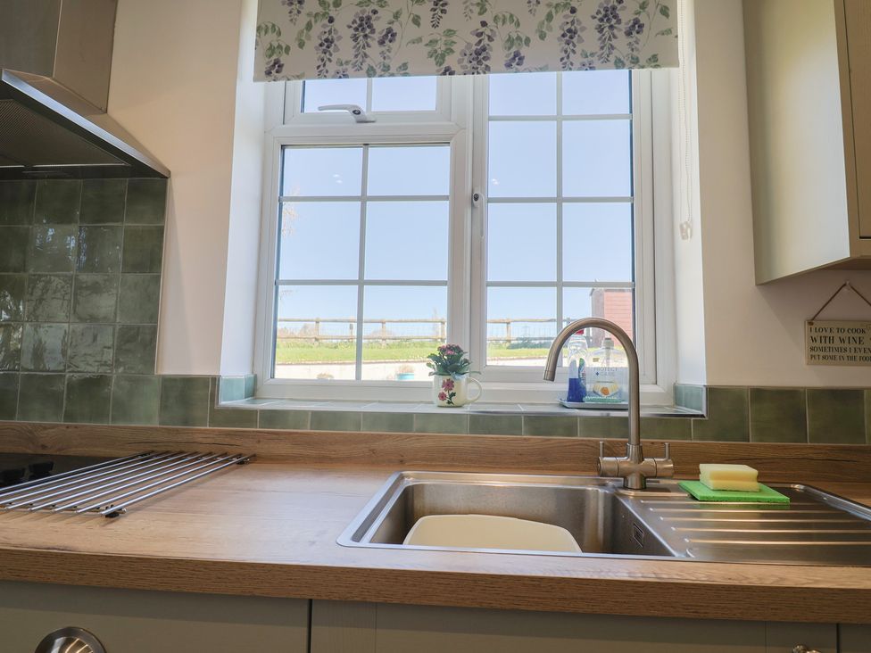 A kitchen with a sink and window at The Old Smithy Dottery near Bridport