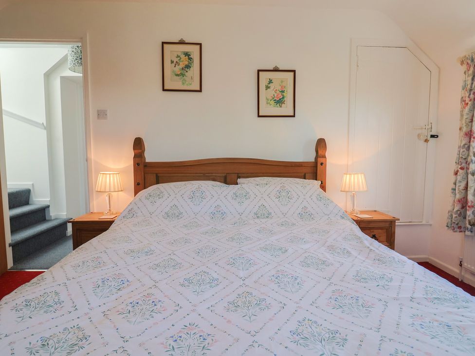 A bedroom with a bed and nightstands at The Old Smithy Dottery near Bridport