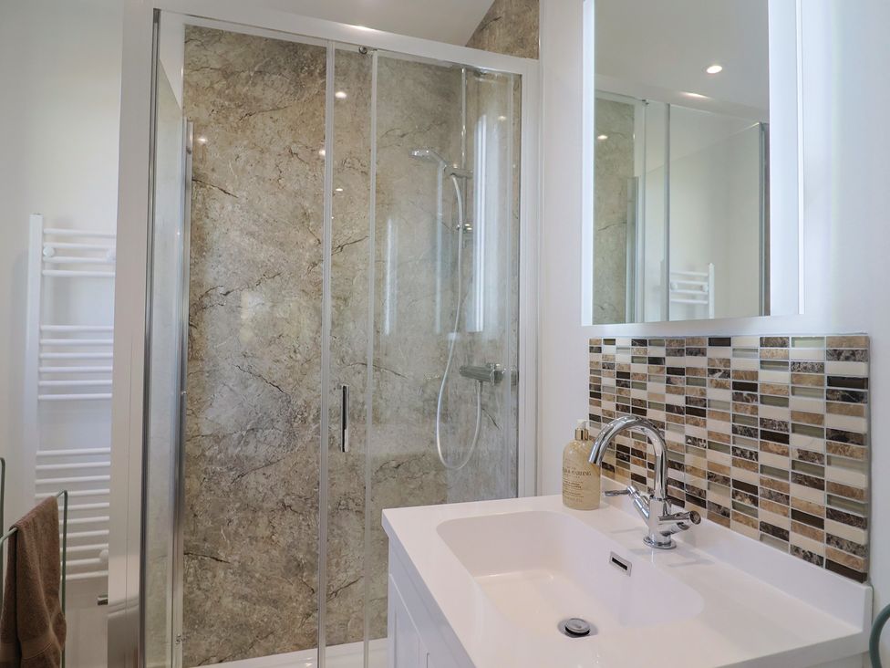 A bathroom with a shower and sink at The Old Smithy Dottery near Bridport
