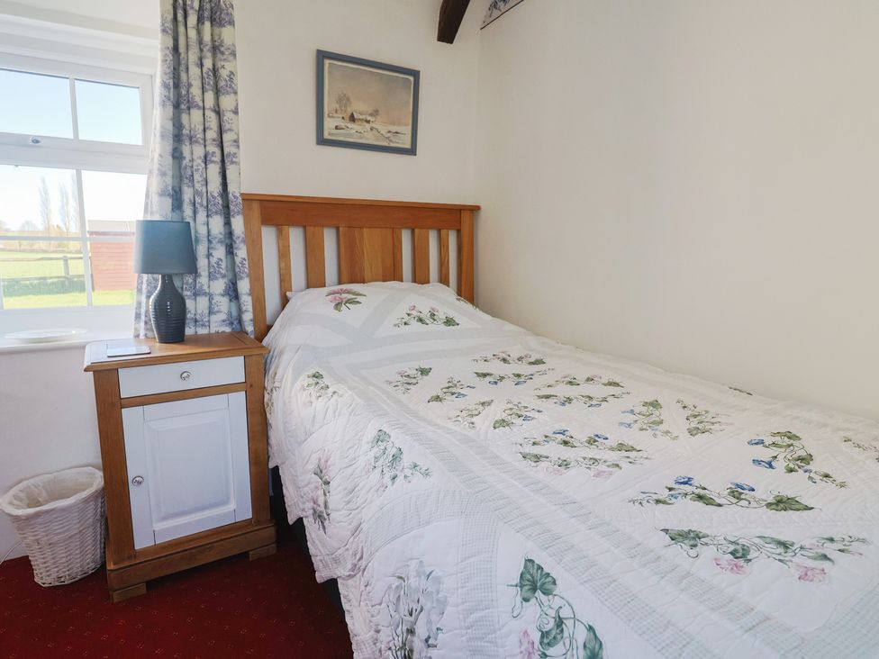 A bedroom with a bed and bedside table at The Old Smithy in Dottery near Bridport