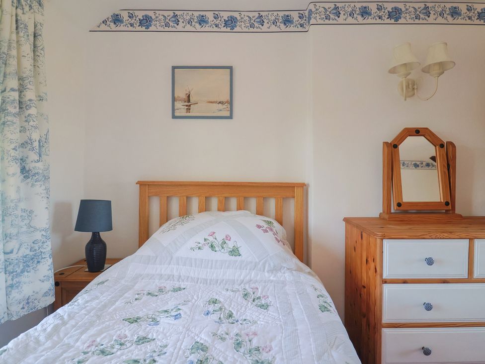 A bedroom with a bed and a dresser at The Old Smithy Dottery near Bridport