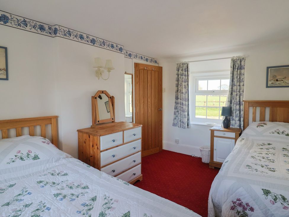 A bedroom with two beds and a dresser at The Old Smithy in Dottery near Bridport