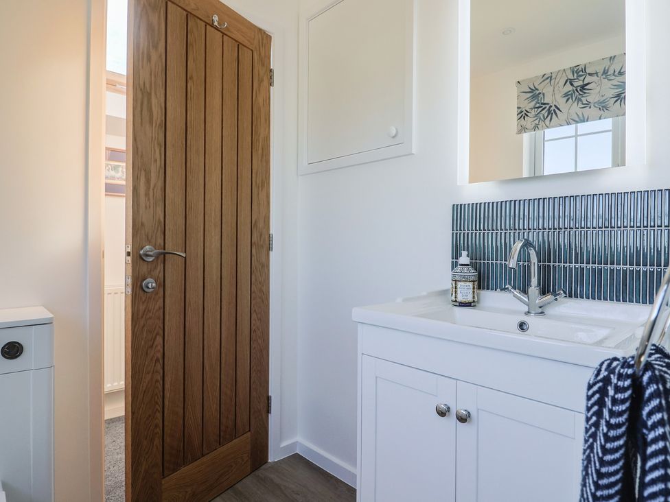 A bathroom with a sink and door at The Old Smithy in Dottery near Bridport