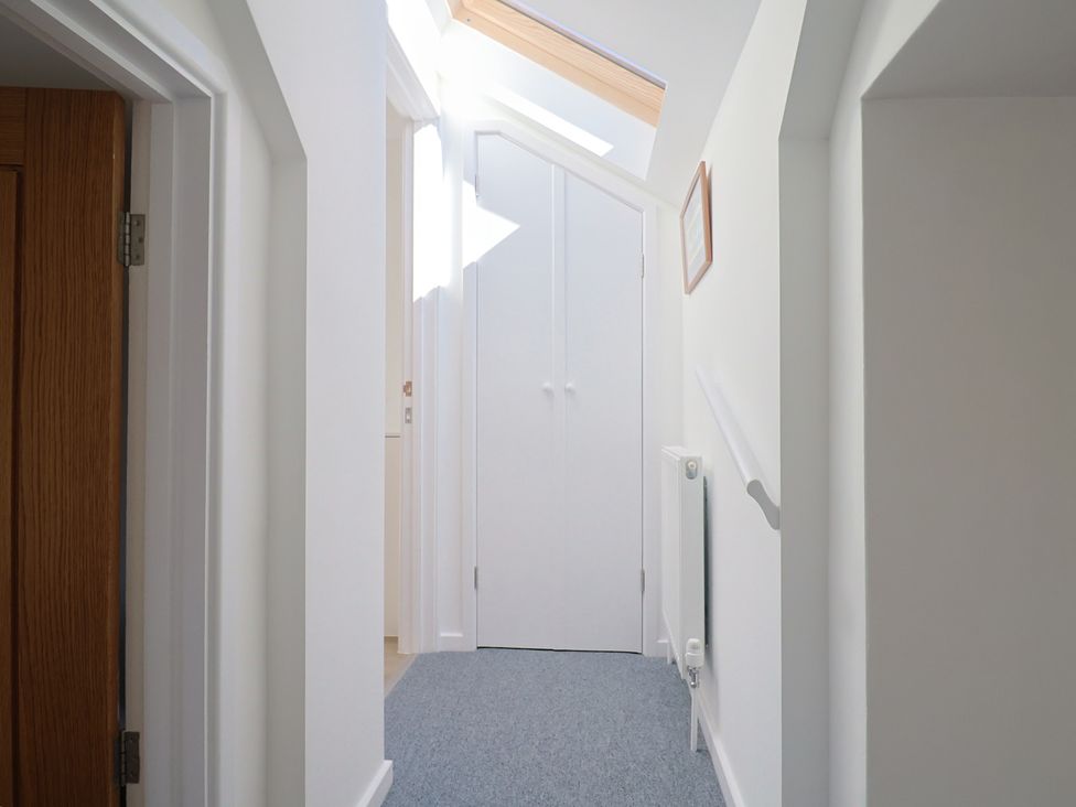 A hallway with a door and cupboard at The Old Smithy Dottery near Bridport