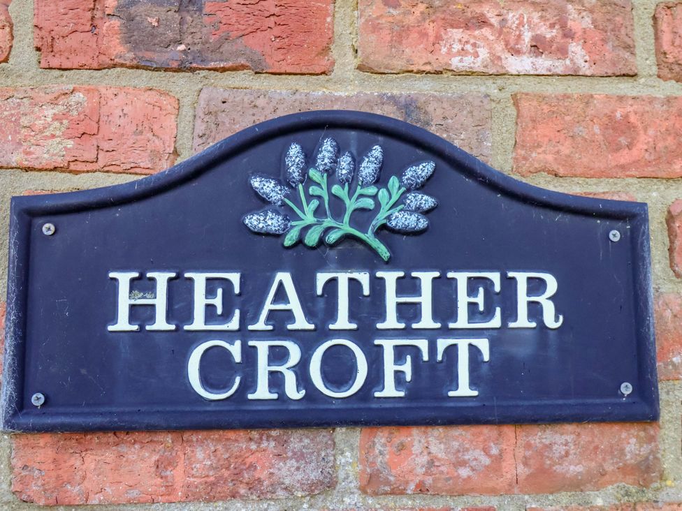 A nameplate on a brick wall at Heather Croft in Robin Hood's Bay