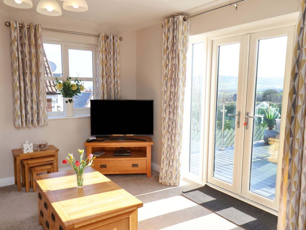 A living room with a television and sliding doors at Heather Croft in Robin Hood's Bay