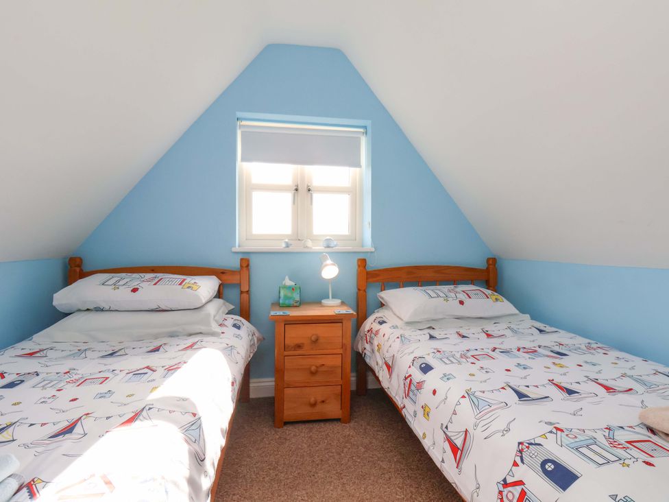A bedroom with two beds and a nightstand at Heather Croft in Robin Hood's Bay