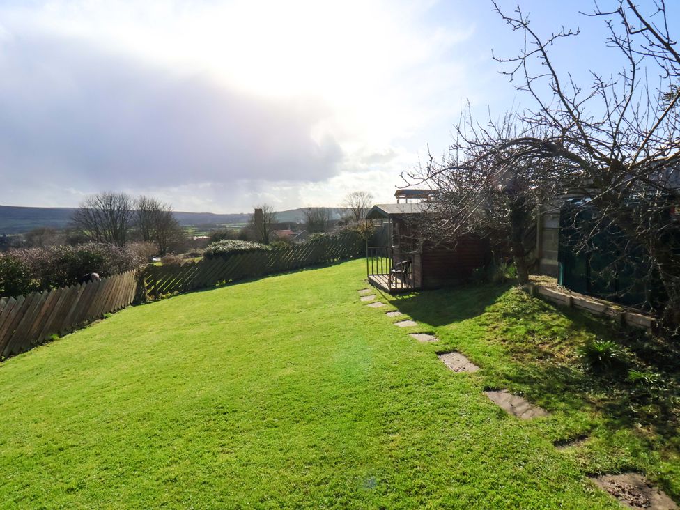 A garden with grass, a shed, and a path at Heather Croft in Robin Hood's Bay