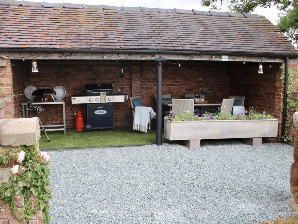 An outdoor area with a barbecue and seating at Lake View Cottage Audley Brow near Market Drayton