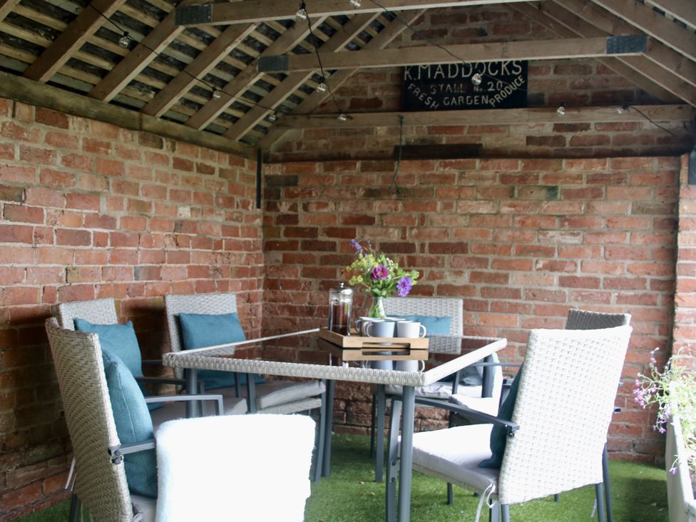 A garden structure with a table and chairs at Lake View Cottage in Audley Brow near Market Drayton