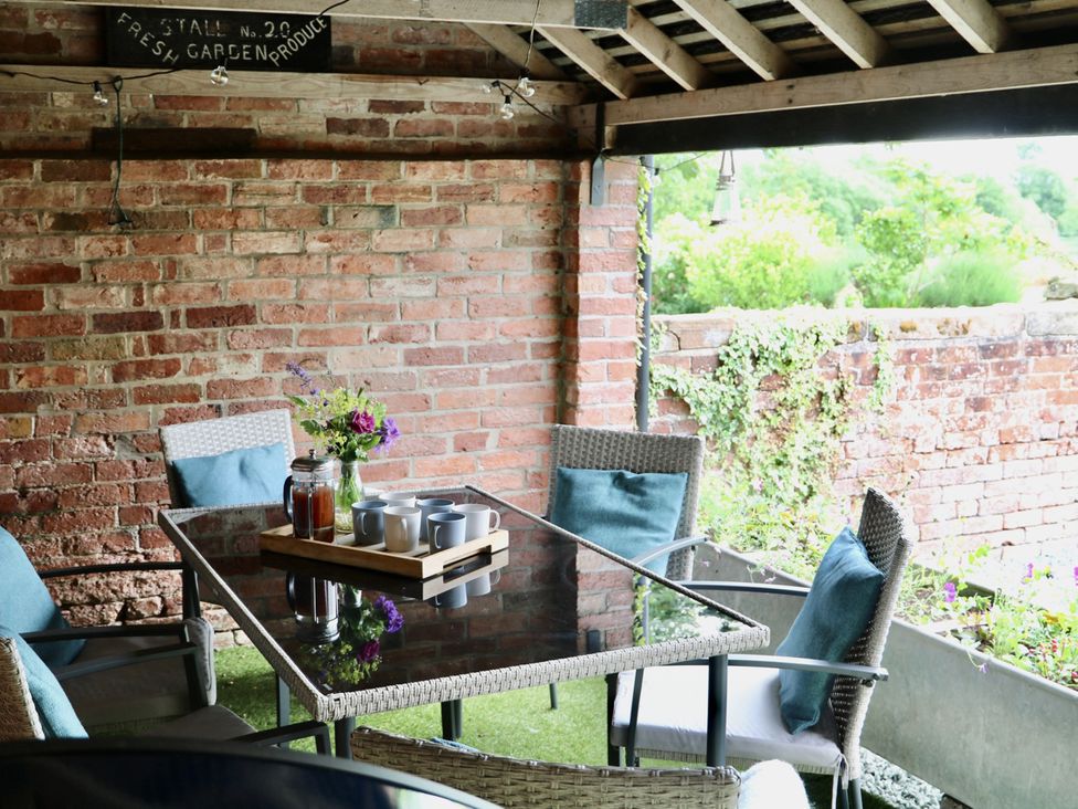 A conservatory with a table and chairs at Lake View Cottage near Market Drayton