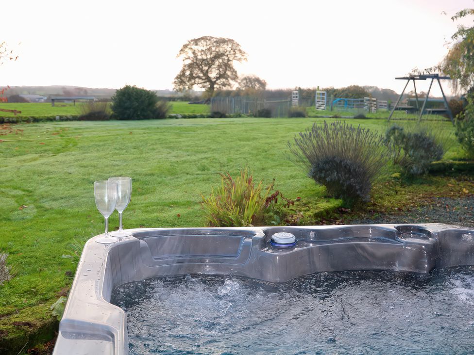 A hot tub with two glasses on the edge at Lake View Cottage in Audley Brow near Market Drayton