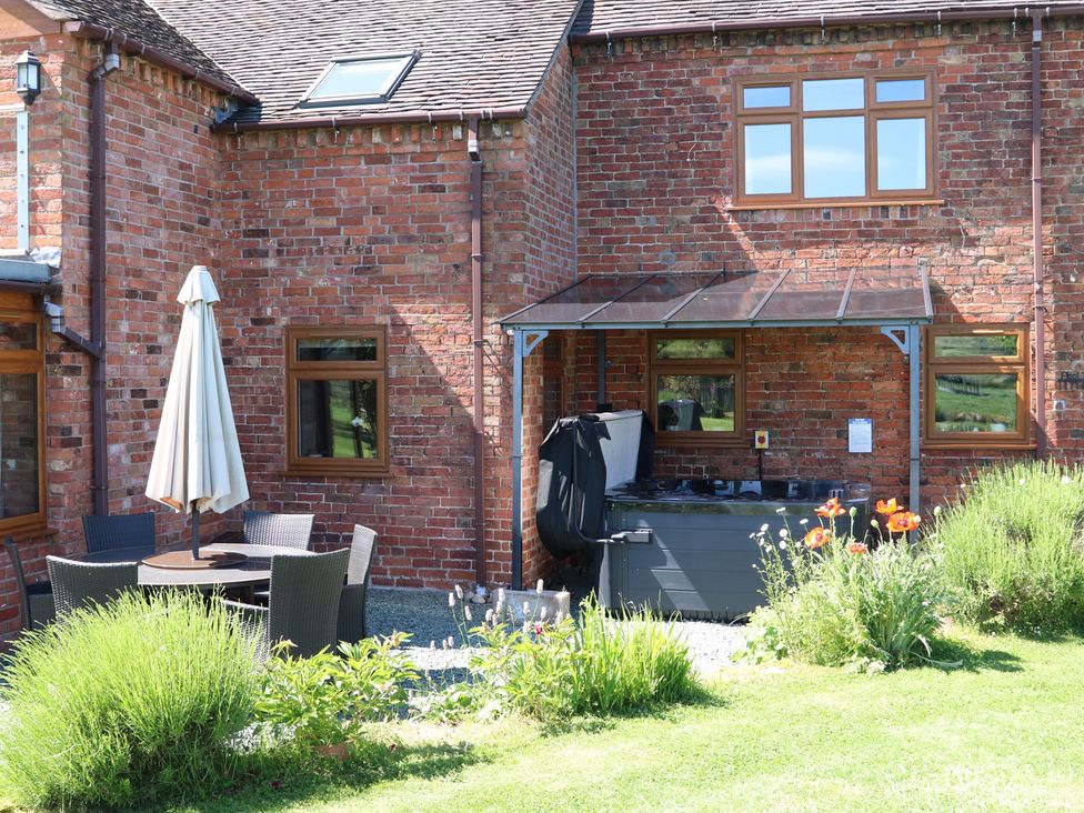 A garden with patio furniture and a hot tub at Lake View Cottage Audley Brow near Market Drayton