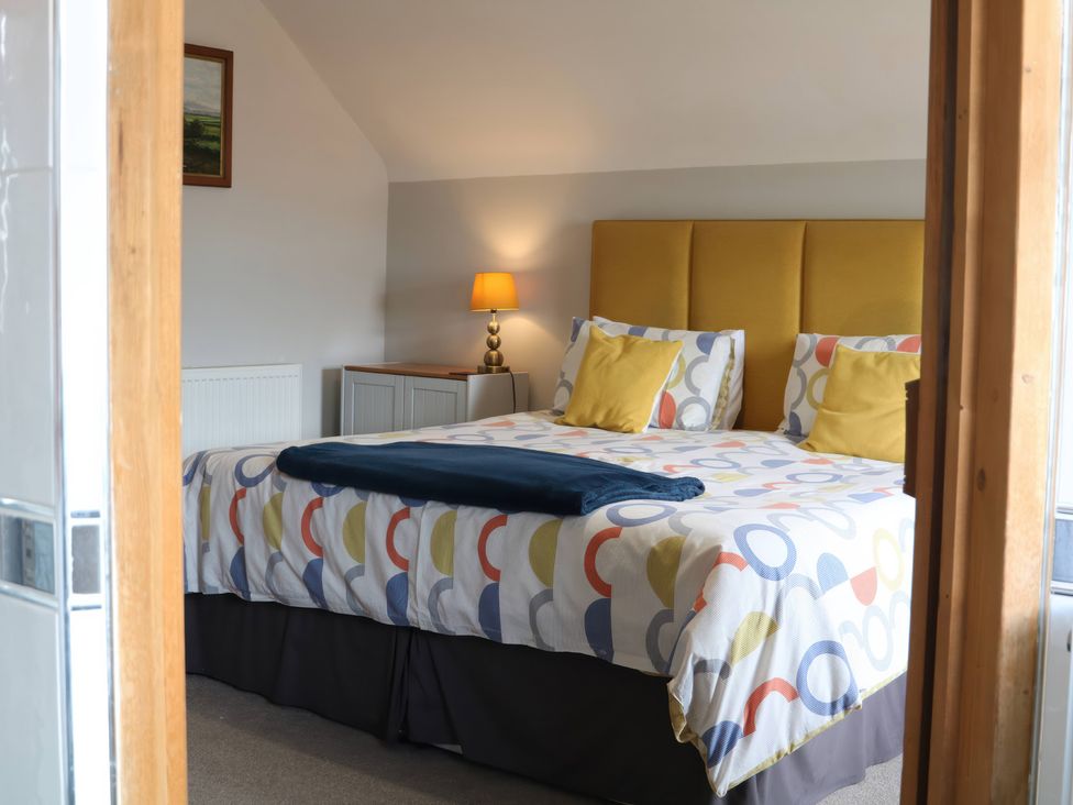 A bedroom with a bed and lamp at Lake View Cottage in Audley Brow near Market Drayton