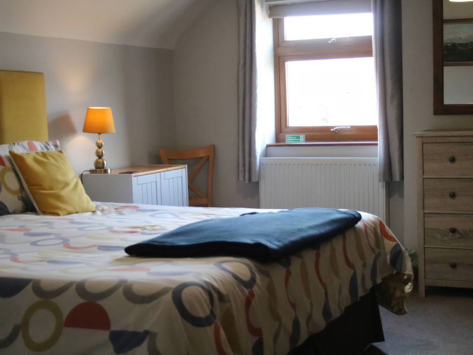 A bedroom with a bed and lamp at Lake View Cottage in Audley Brow near Market Drayton